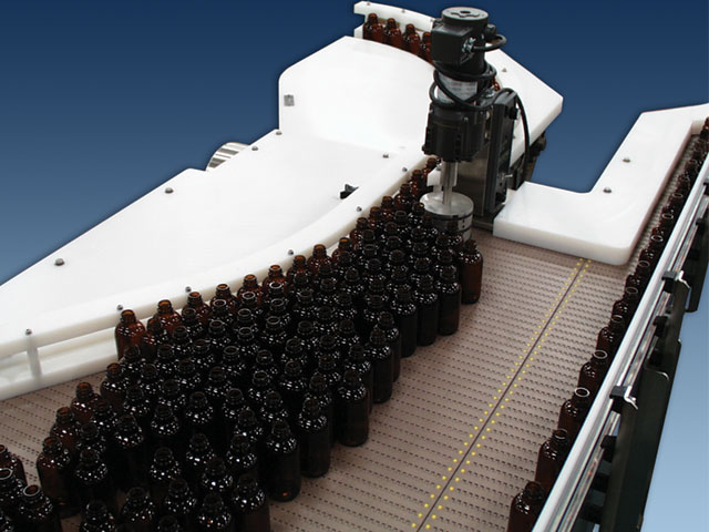 Garvey Bi-Flow pictured from above with glass bottles on the conveyor belt.
